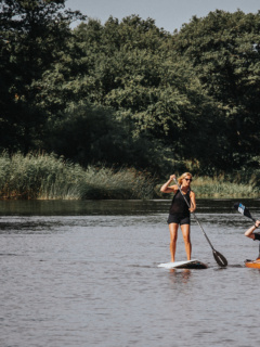 Två personer paddlar kajak och sup på Rönneå.