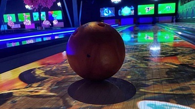 En bild med ett bowlingklot i centrum med discokänsla.
