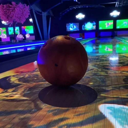 En bild med ett bowlingklot i centrum med discokänsla.