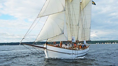 Skonaren Nina, segelfartyg i trä med vita segel. Seglar på sundet med Helsingborg i bakgrunden.