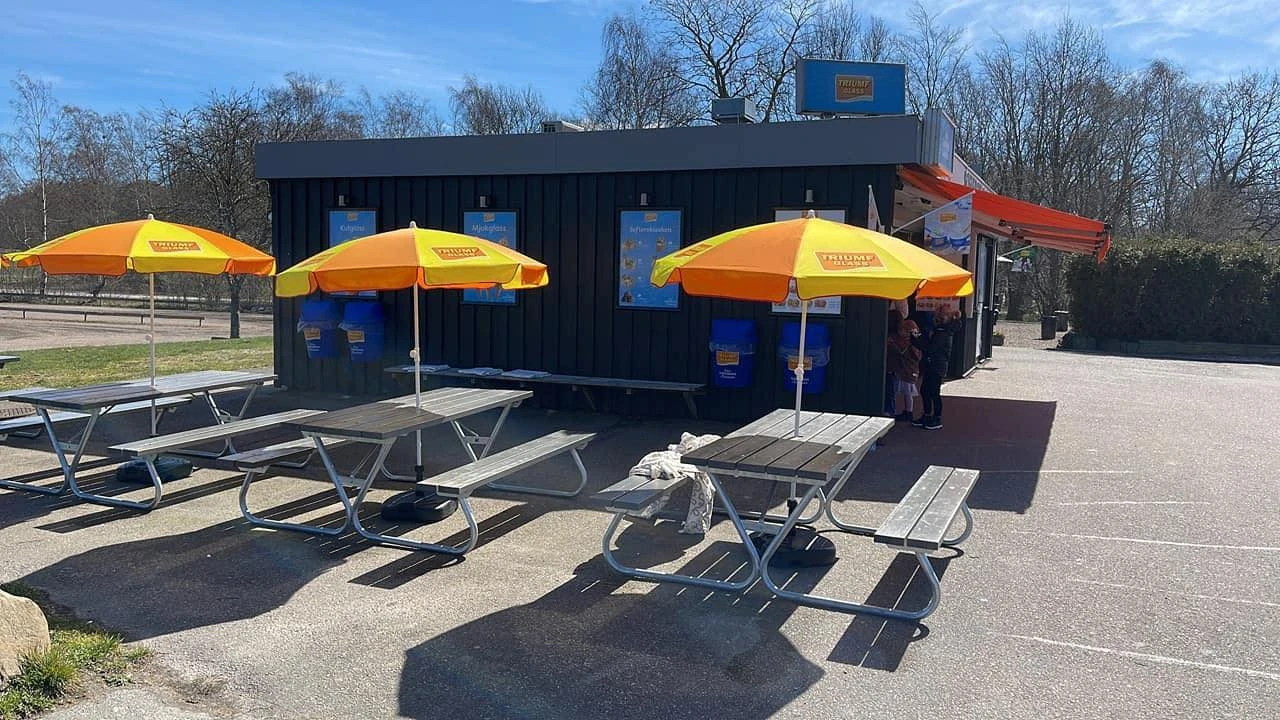 Kiosk med bänkar och parasoll uppfällda.