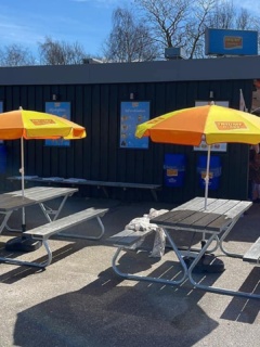 Kiosk med bänkar och parasoll uppfällda.