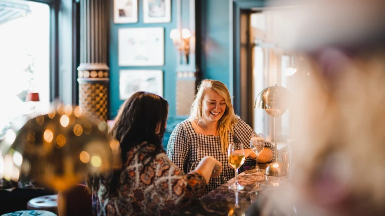 Två kvinnor tar en drink i en hotellbar