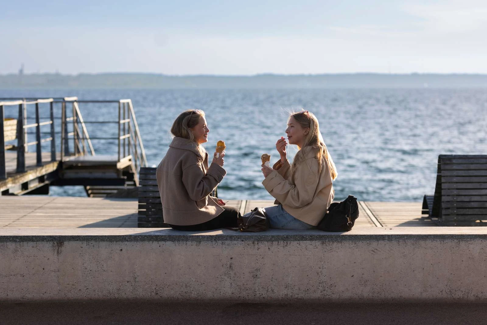 2 unga flickor äter glass vid havet vid gröningen.