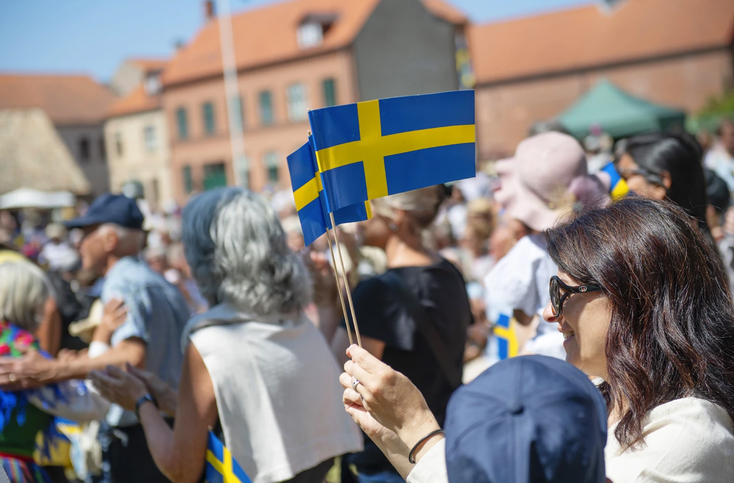 Nationaldagsfirande på Fredriksdal med vajande svenska flaggor