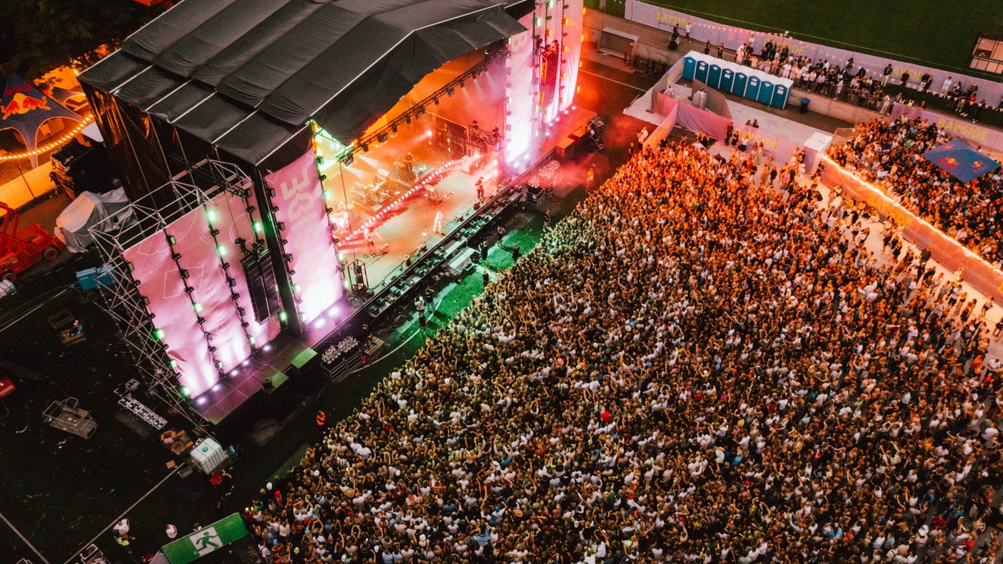 folkhav framför en musikscen i skymning.