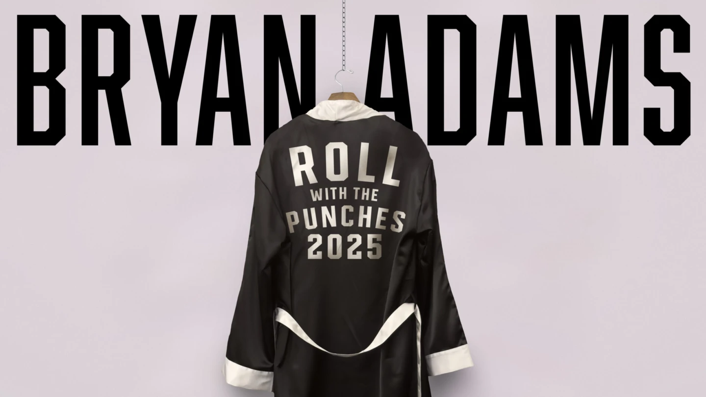 text Bryan Adams, ovanför hänger en svart rock med text på ryggen.