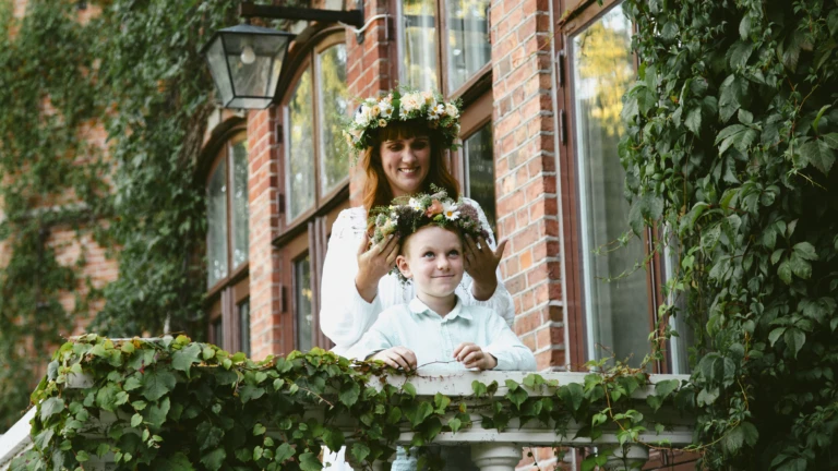 mamma med dotter i midsommarkrans på Sofieros slottstrappa