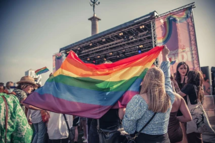 En grupp människor håller en regnbågsflagga på en musikfestival