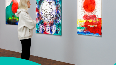 En kvinna tittar på en utställning med tavlor