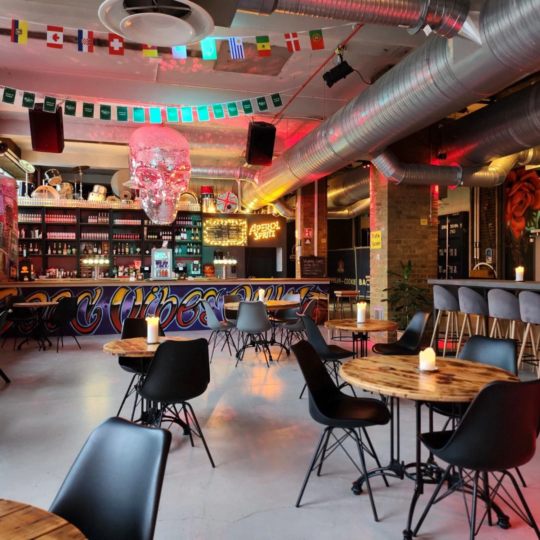En restaurang med bord och stolar framför en bar.