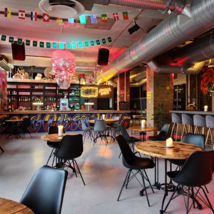 En restaurang med bord och stolar framför en bar.