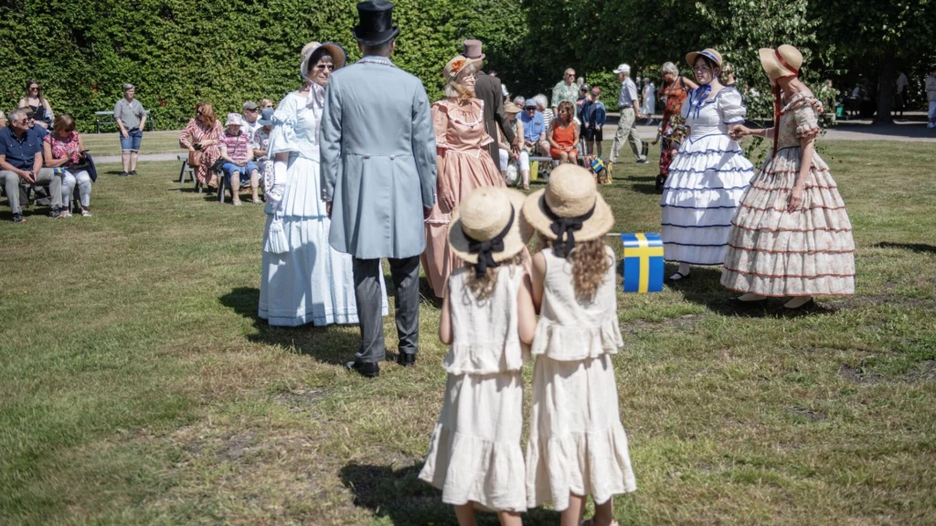 Ett nationaldagsfirande på Fredriksdal. två flickor i ett folkvimmel.