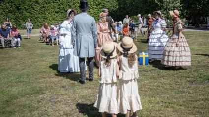 Ett nationaldagsfirande på Fredriksdal. två flickor i ett folkvimmel.