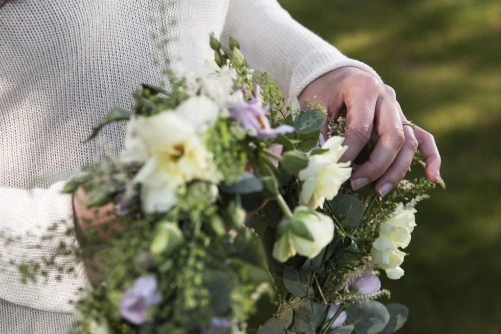 en blomsterkrans med creamvita och lila blommor.