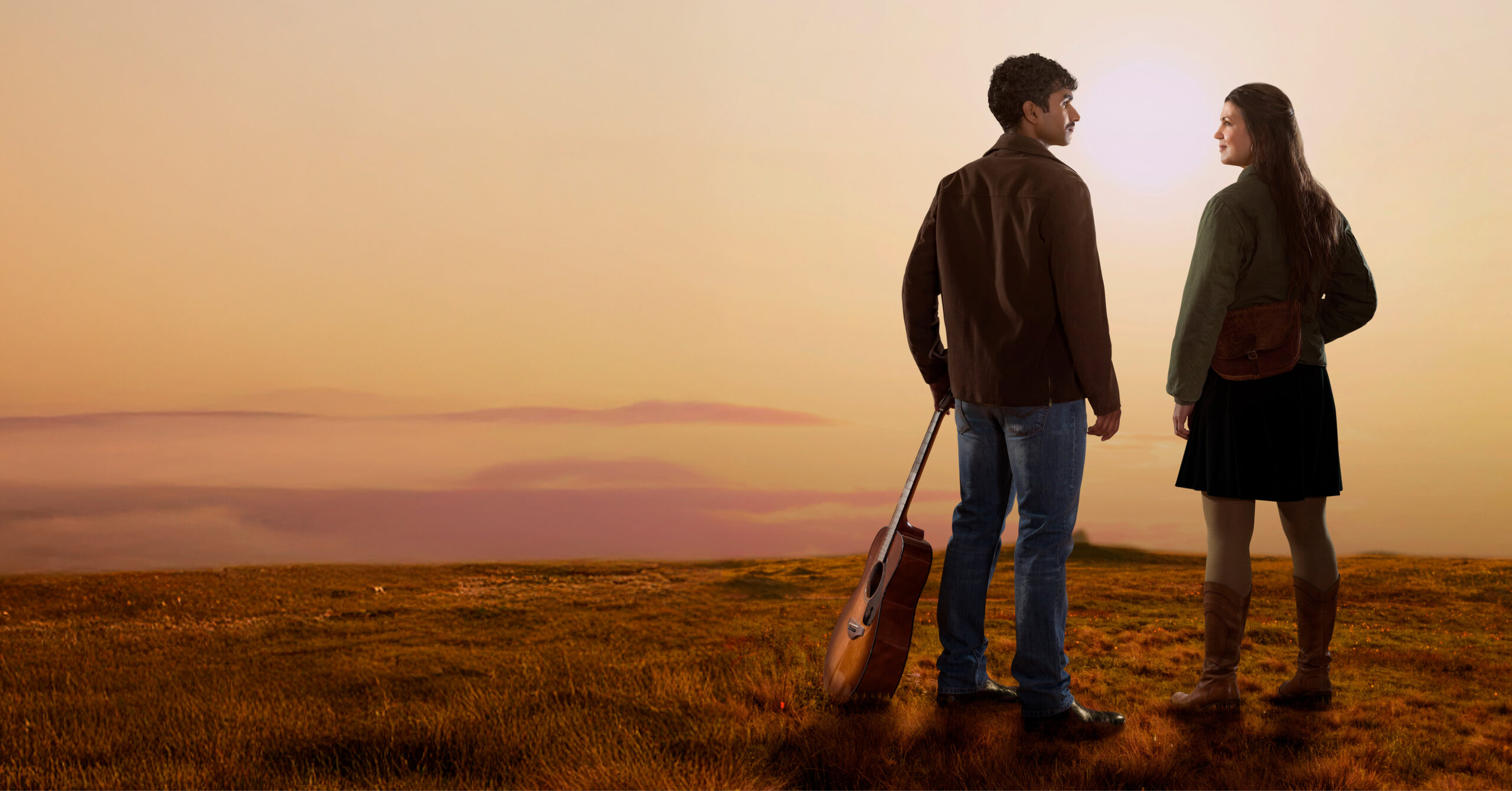 en man och en kvinna utomhus i skymning med en gitarr.