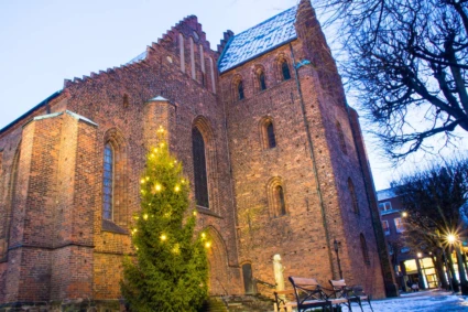 julig bild på utsidan av Maria Kyrkan julgran i förgrunden