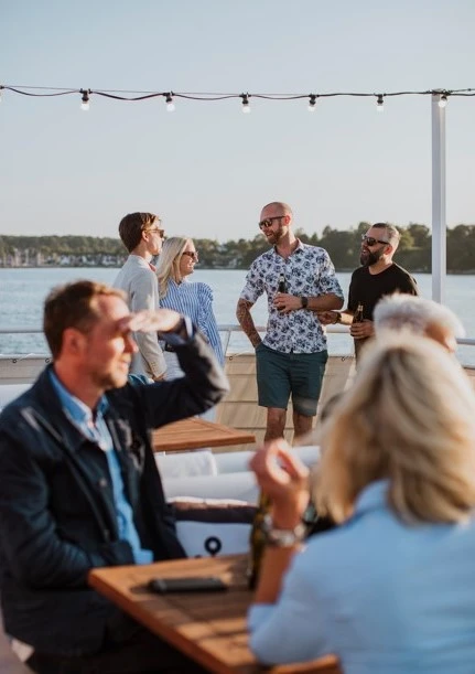 Glada människor socialiserar sig ombord på båt med havet i bakgrunden