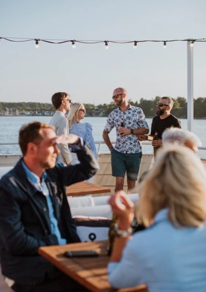 Glada människor socialiserar sig ombord på båt med havet i bakgrunden