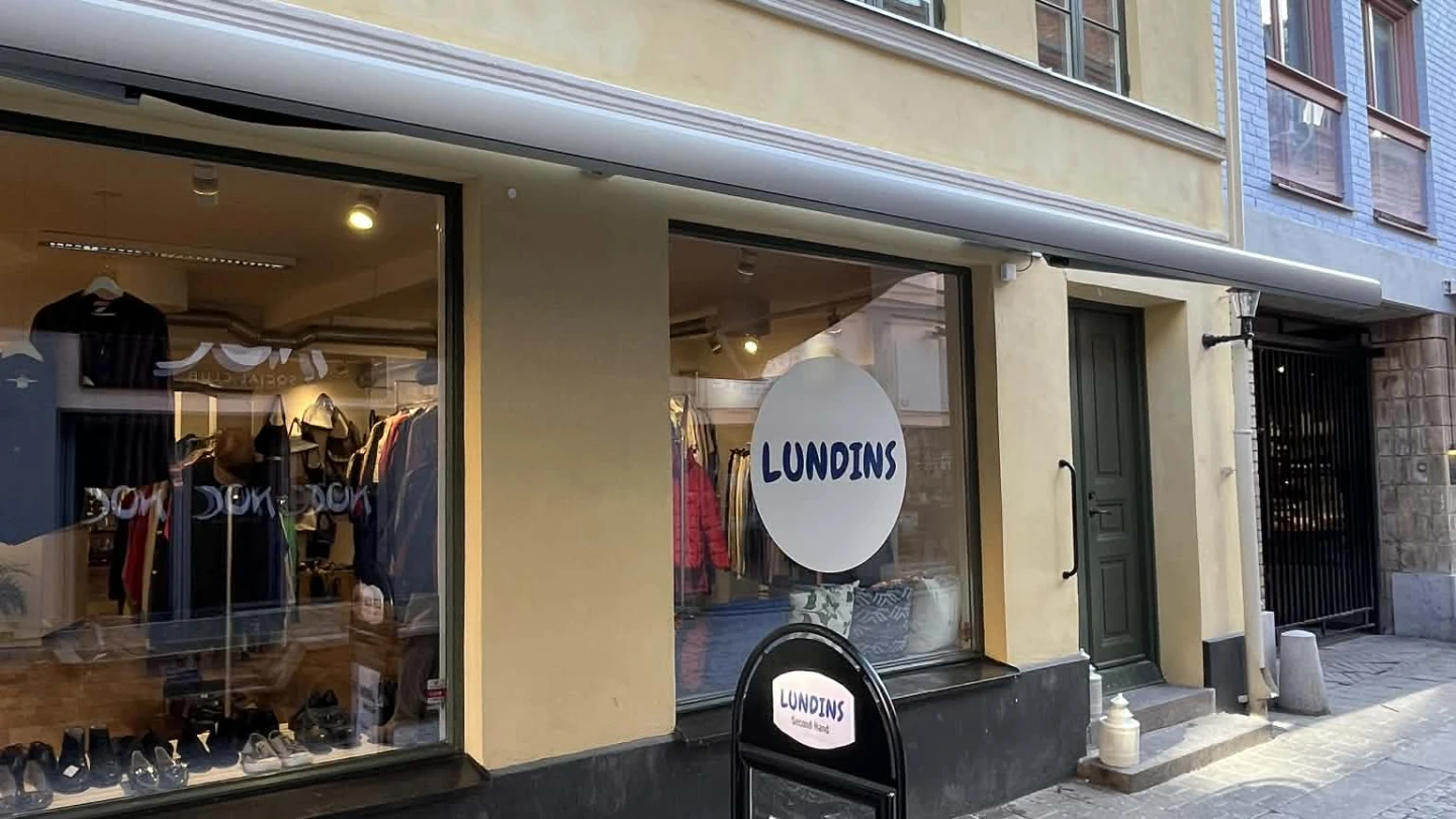 Fasad på en gul byggnad med en skylt utanför