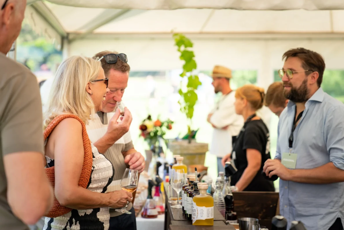 två personer smakar på drycker under en dryckesfestival
