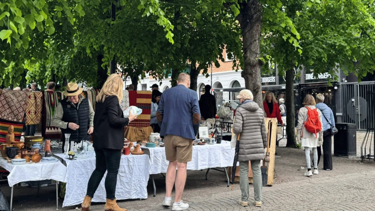 bild på en loppis utomhus. Bord med olika saker.