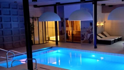 spa pool i dovt ljus med solsängar i bakgrunden och en bastu