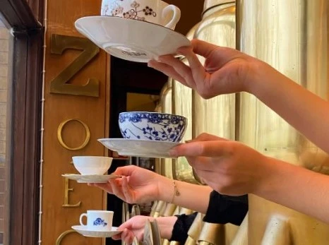 Bild visar händer med kaffekoppar på Café 1886