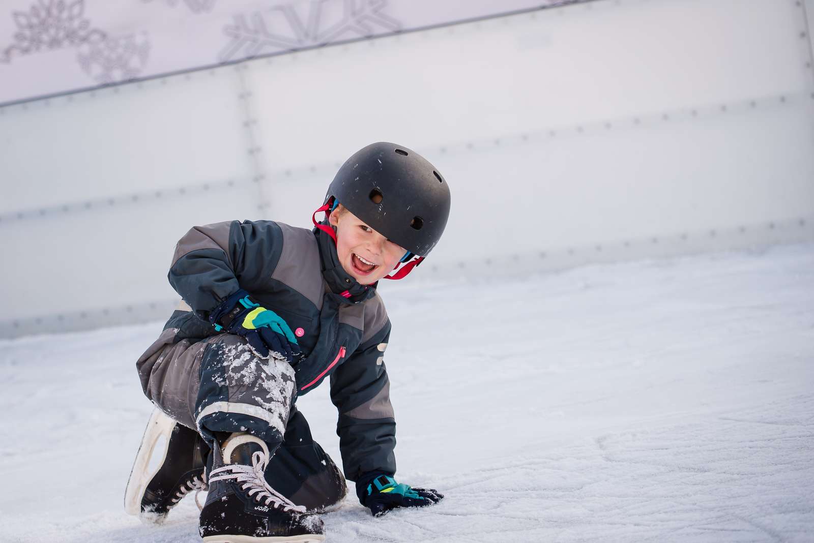 en glad pojke på en isbana med skridskor