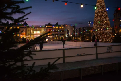 en isbana utomhus med juliga dekorationer i kvällsljus