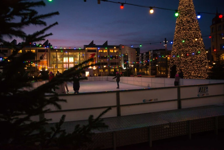 en isbana utomhus med juliga dekorationer i kvällsljus