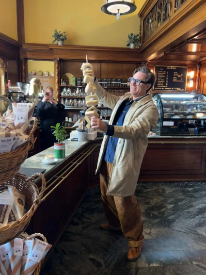 en man med 5 bulle med bulle på ett spett inne på ett cafe