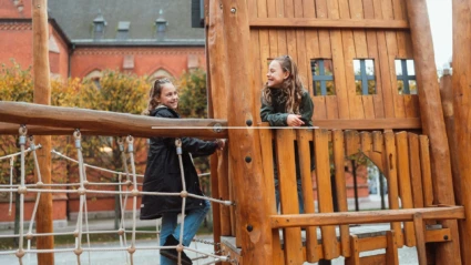 2 barn på en lekplats i trämaterial