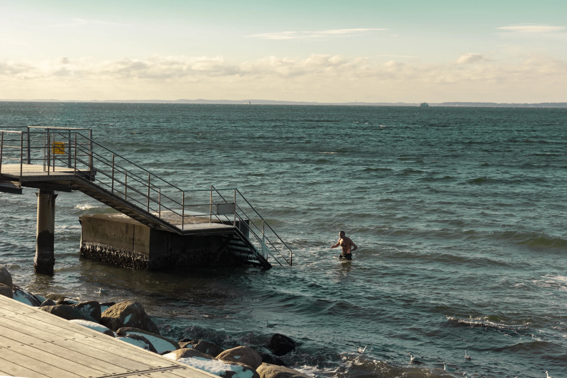 en person badar vid en brygga.