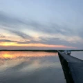 solnedgångsbild över en brygga och en ö