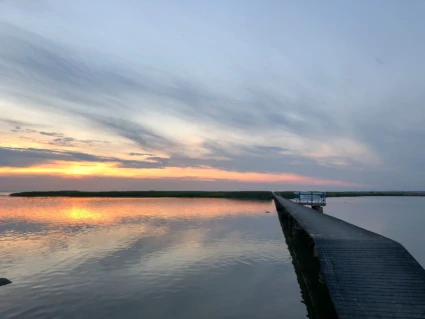 solnedgångsbild över en brygga och en ö