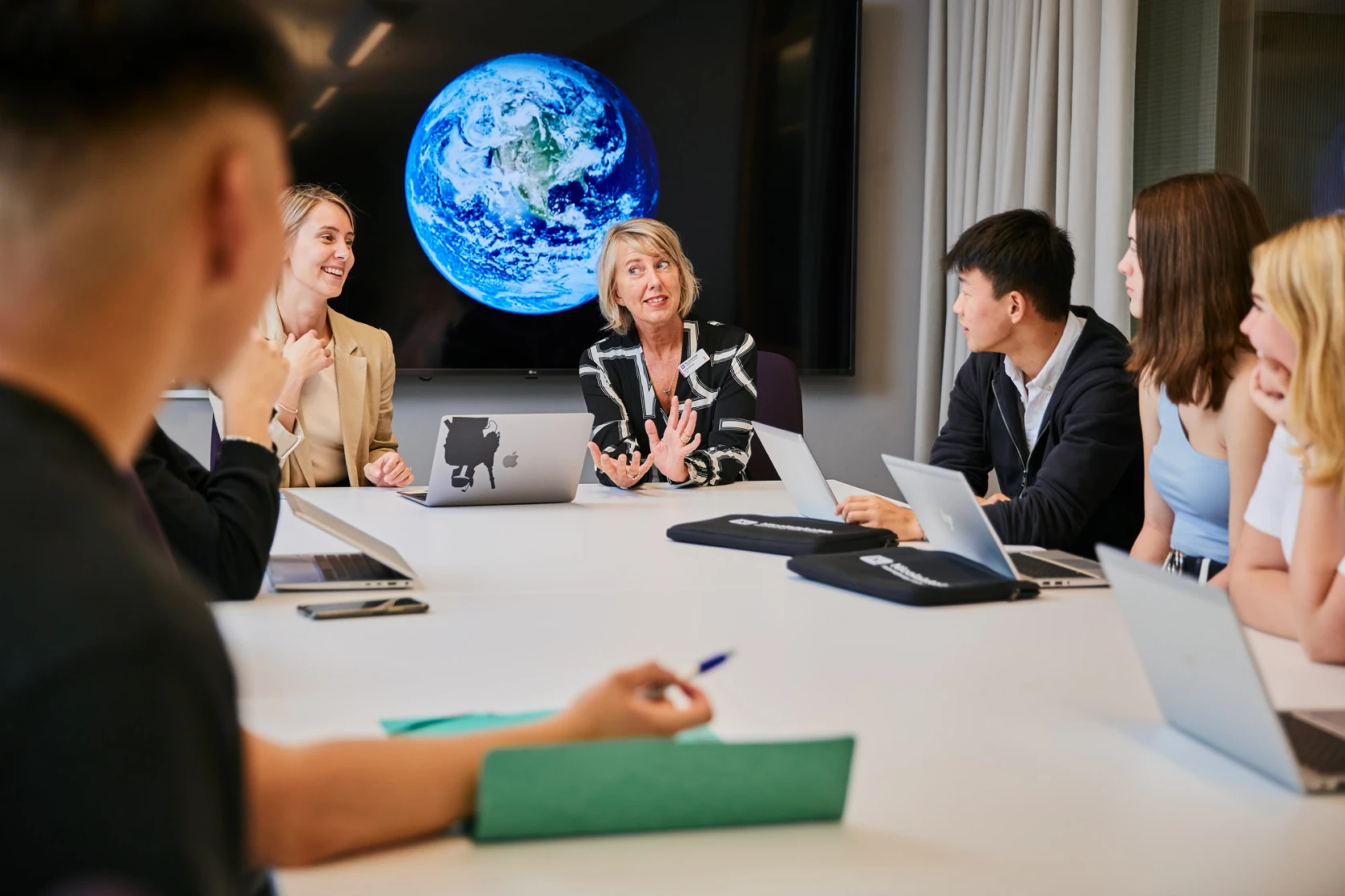 Elever och lärare i ett mötesrum.