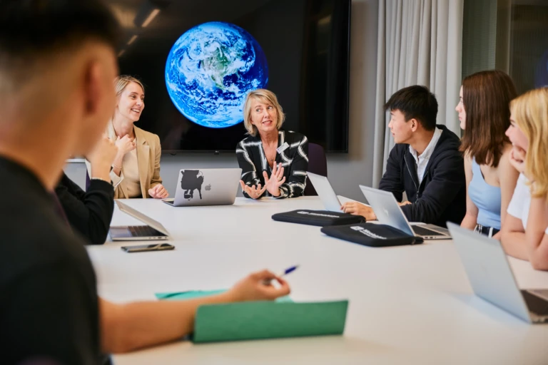 Elever och lärare i ett mötesrum.