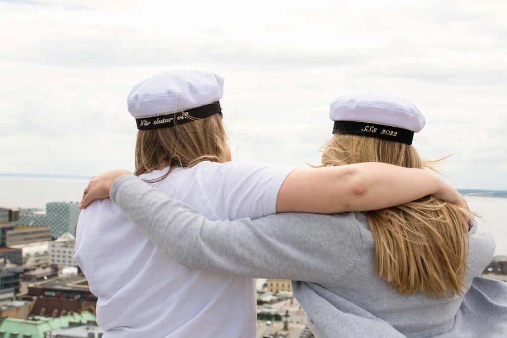 Elever med studentmössor som tittar ut över Helsingborg.