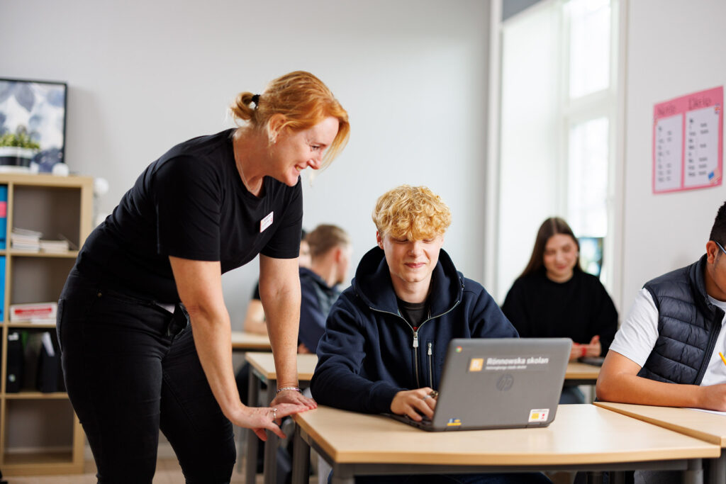 Lärare och elev i samspel i klassrum.