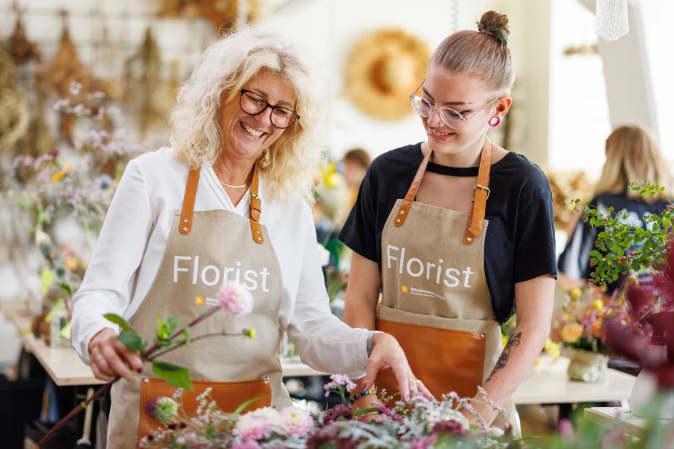 Yrkeslärare och elev binder en blombukett tillsammans