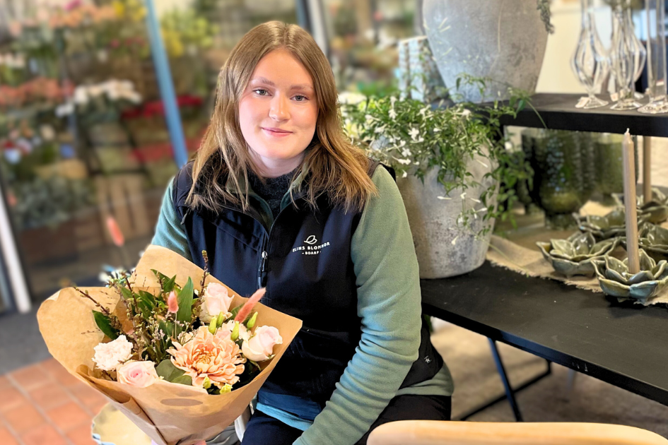 Lovisa, florist, i en blombutik med bukett. 
