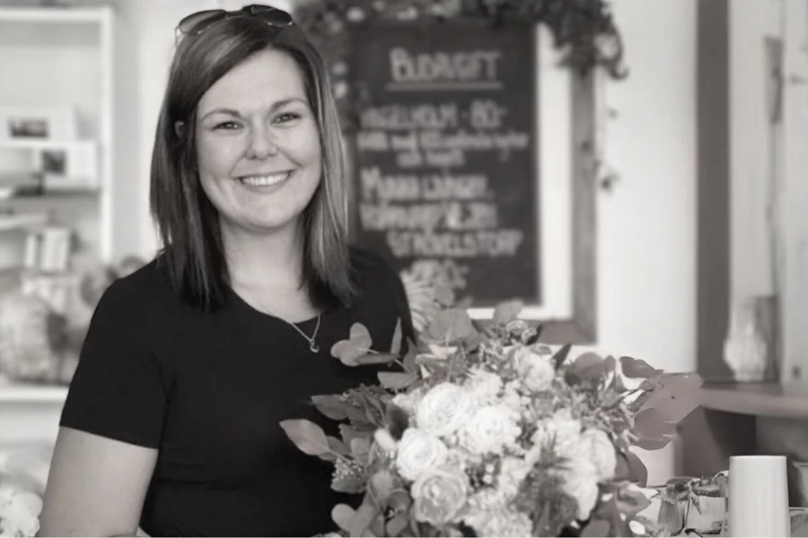 Pauline håller upp en bukett i hennes butik ”Paulines blommor och blad”