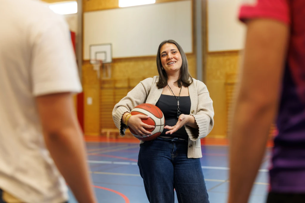elev står i idrottshall med en basketboll