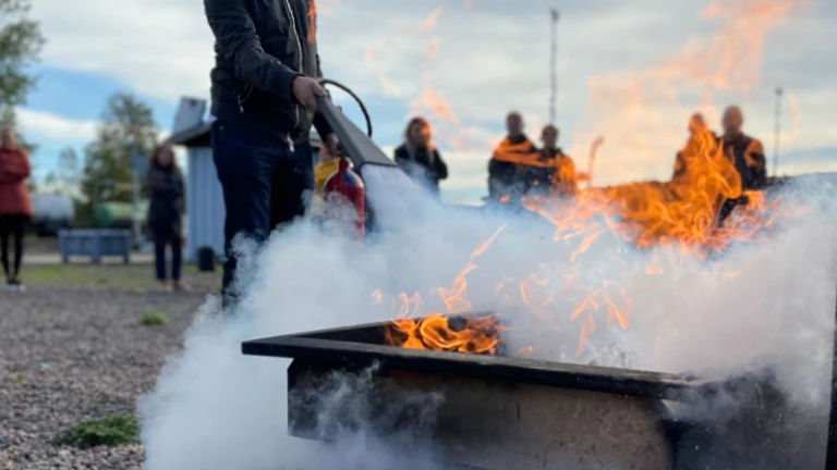 Person som släcker en brand i ett kar under en övning