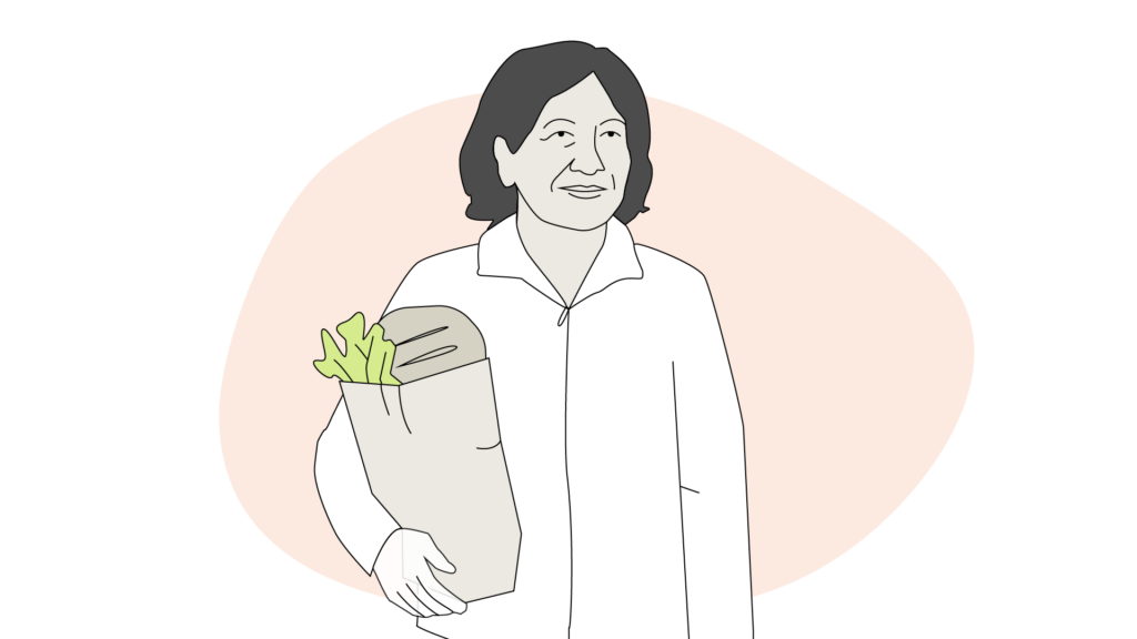 En kvinna bär på en matkasse