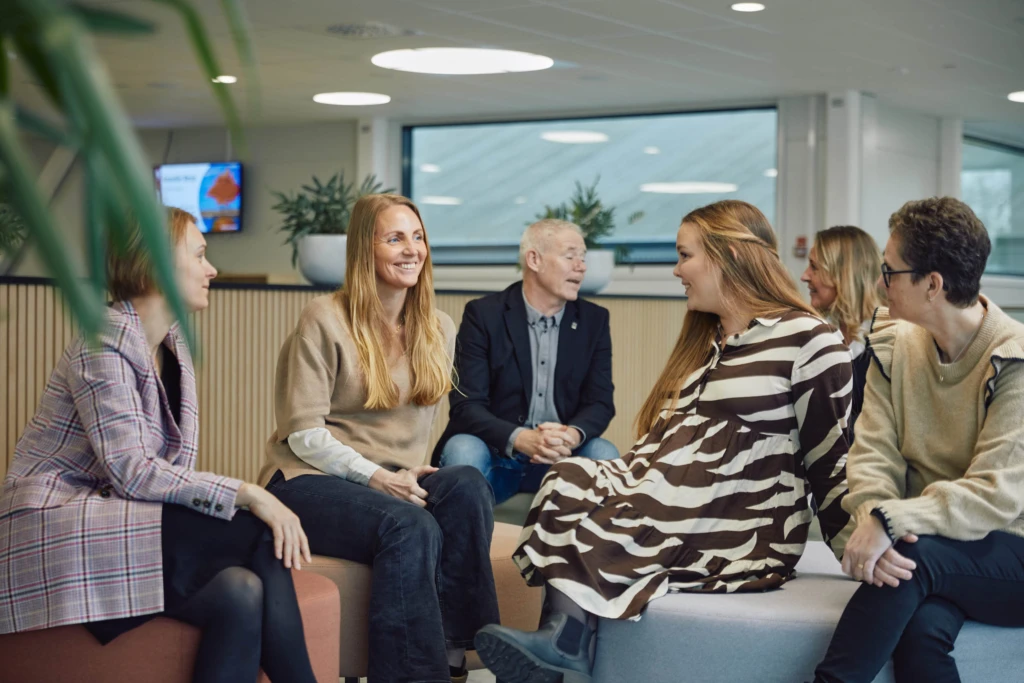 Kollegor i gruppsamtal i en modern arbetsmiljö.
