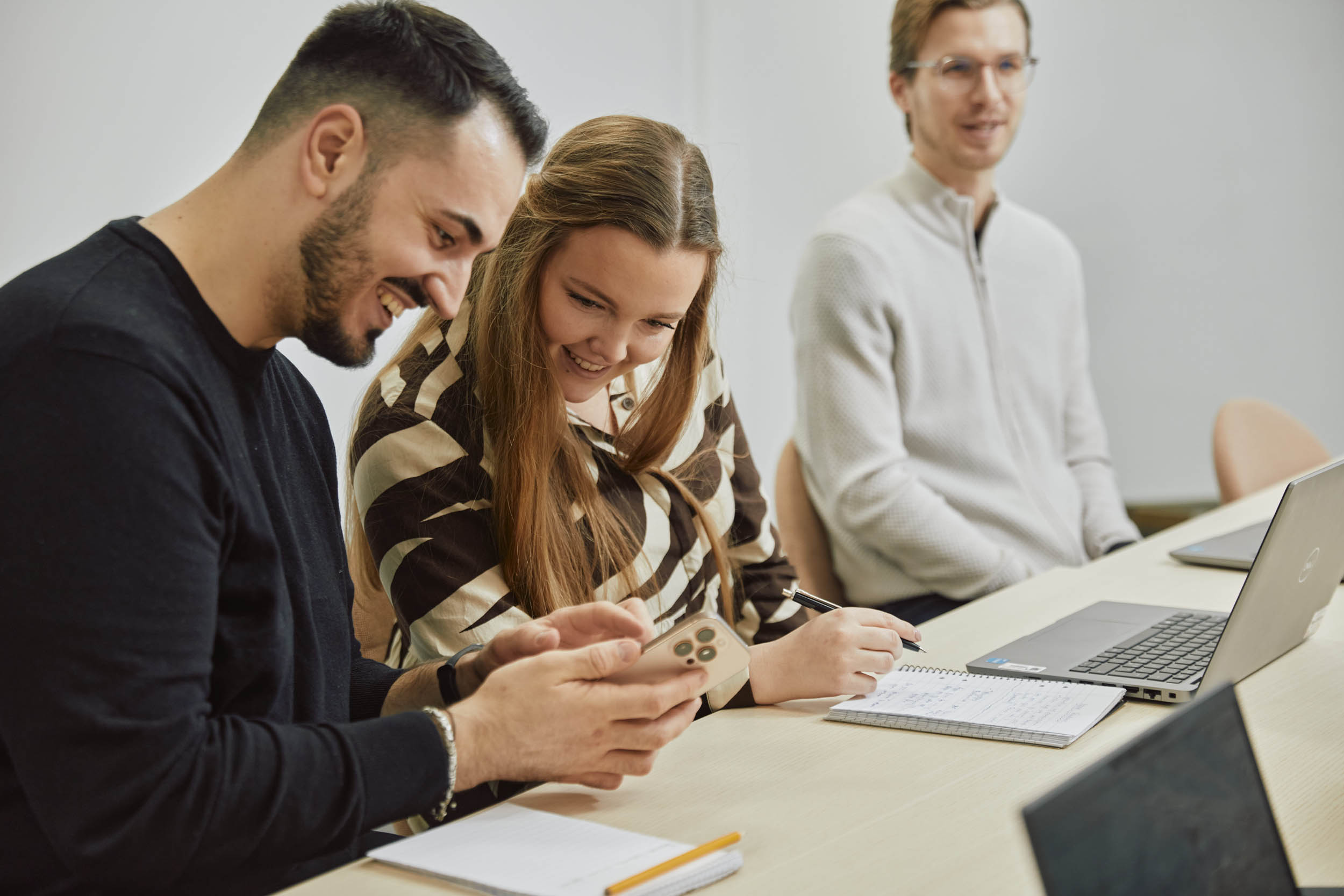 Två personer delar ett skratt under ett möte.