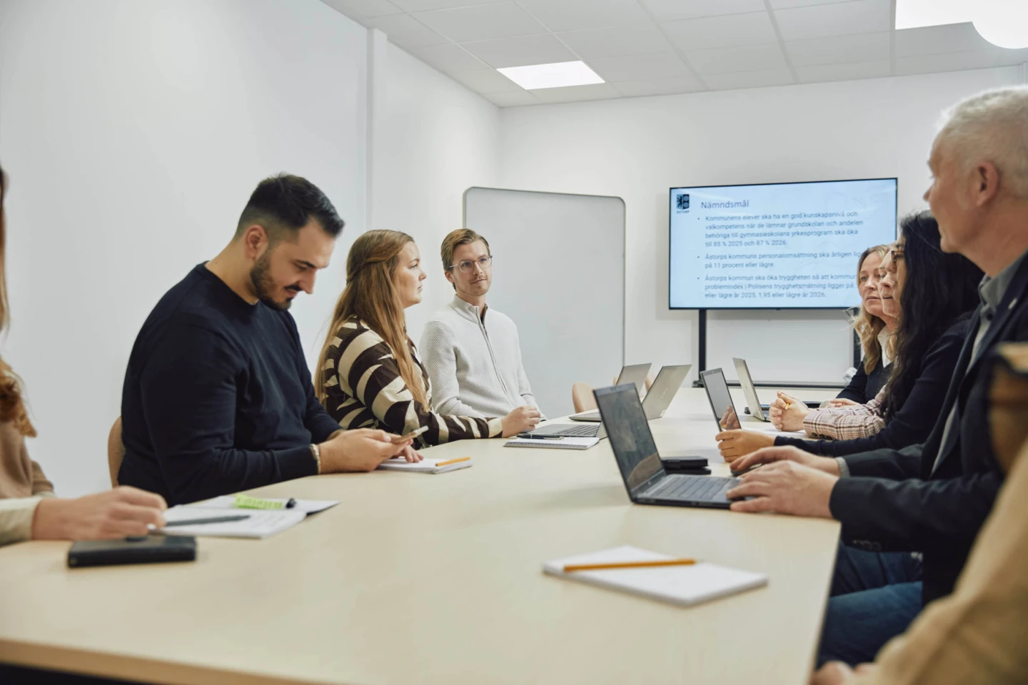 Grupp i möte med presentation av nämndsmål på skärm.