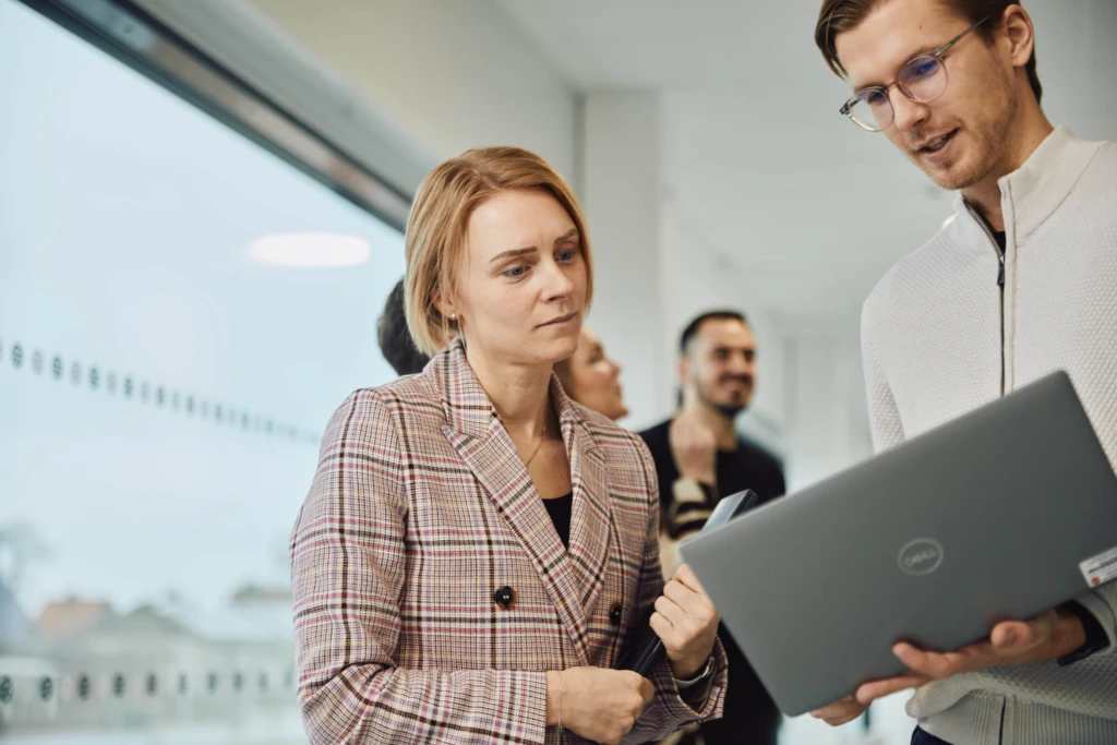 Två kollegor tittar på en laptop tillsammans.